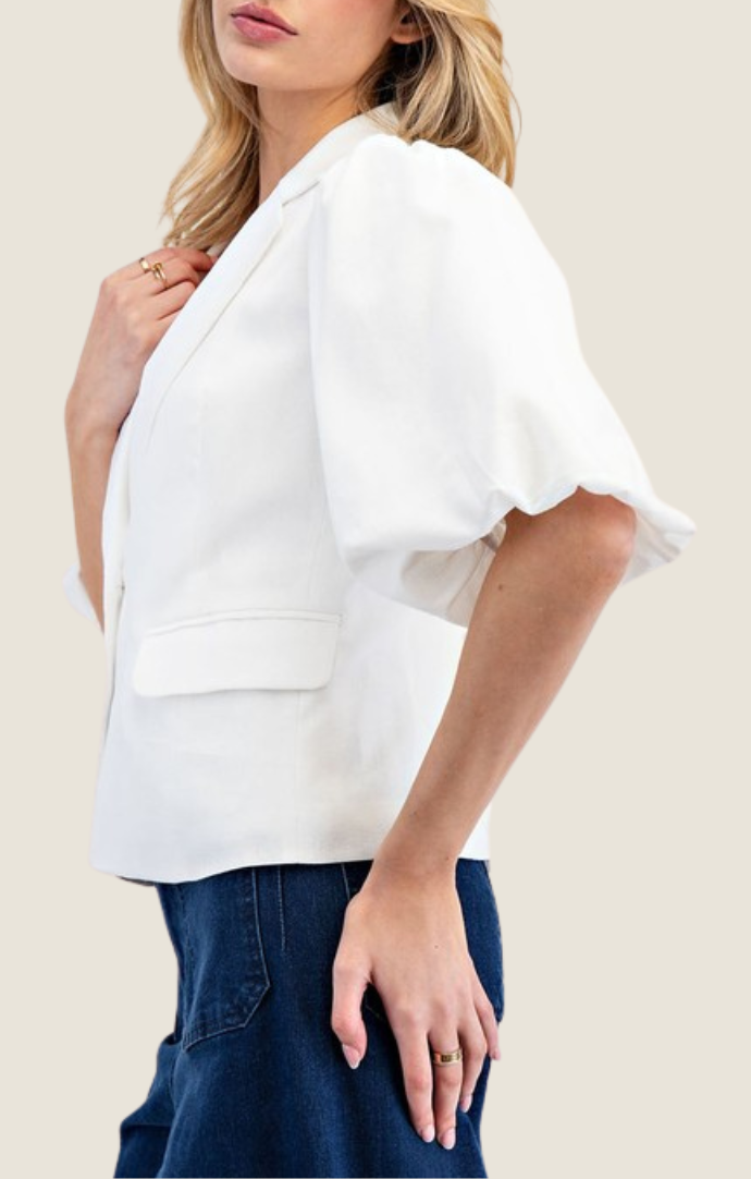 Adriel Off White Blazer Top featuring lapel collared v-neckline, double button down front, pinched shoulders, half bubble sleeves, and side flap pocket detailing