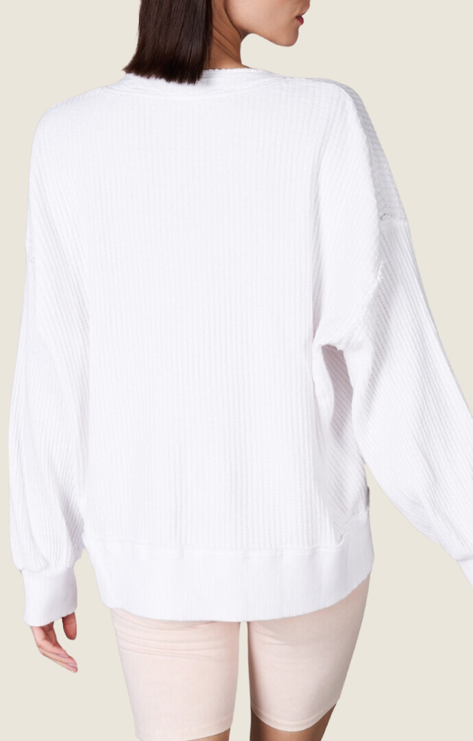 White waffle knit long sleeve top with open placket, balloon sleeves, and raw edge detailing MT210266-WHT